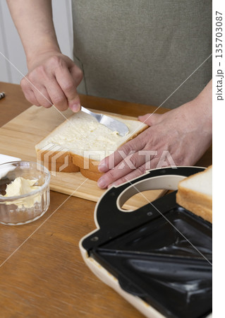 ホットサンドメーカーでホットサンドを作る手元 ホットサンドメーカーでホットサンドを作る手元 135703087