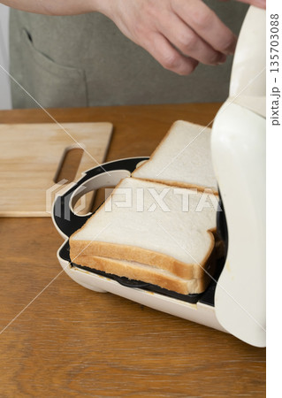 ホットサンドメーカーでホットサンドを作る手元 ホットサンドメーカーでホットサンドを作る手元 135703088