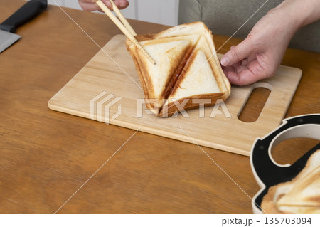 ホットサンドメーカーでホットサンドを作る手元 135703094