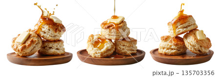 Buttermilk biscuits topped with syrup and butter, stacked on a wooden plate, isolated on white background, concept of breakfast 135703356