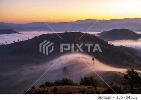 Landscape of Morning Mist with Mountain Layer. mountain ridge and clouds in rural jungle bush forest Landscape of Morning Mist with Mountain Layer. mountain ridge and clouds in rural jungle bush forest 135704618