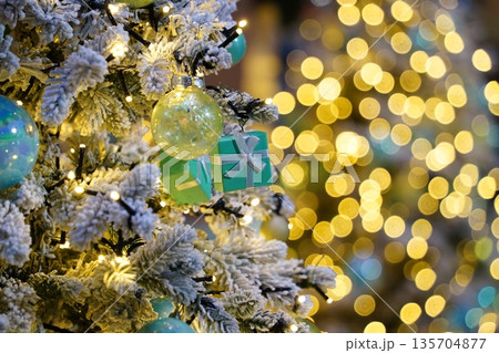 Festive Christmas Tree with Snowy Branches, Teal Ornaments, and Sparkling Bokeh Lights Festive Christmas Tree with Snowy Branches, Teal Ornaments, and Sparkling Bokeh Lights 135704877