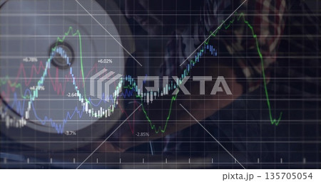 Analyzing man in plaid shirt tracking financial charts at laptop in home office, with desk lamp Analyzing man in plaid shirt tracking financial charts at laptop in home office, with desk lamp 135705054