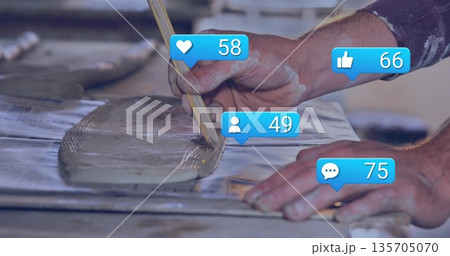 Spreading male hands applying gray mortar on work bench with notched trowel and notification icons Spreading male hands applying gray mortar on work bench with notched trowel and notification icons 135705070