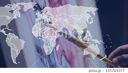 Holding brush applying colorful pigments across canvas on easel in art studio, world map overlay Holding brush applying colorful pigments across canvas on easel in art studio, world map overlay 135705077