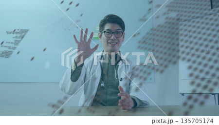 Waving doctor in lab coat gesturing at table in office, with stethoscope glasses whiteboard overlay Waving doctor in lab coat gesturing at table in office, with stethoscope glasses whiteboard overlay 135705174
