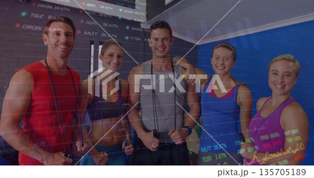 Standing five fitness members holding jump ropes in fitness studio, with financial chart overlay 135705189
