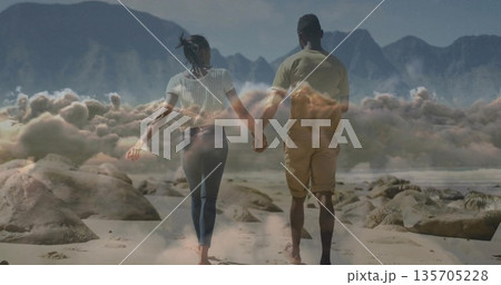 Walking barefoot couple holding hands along sandy beach, with smooth boulders and scattered rocks Walking barefoot couple holding hands along sandy beach, with smooth boulders and scattered rocks 135705228