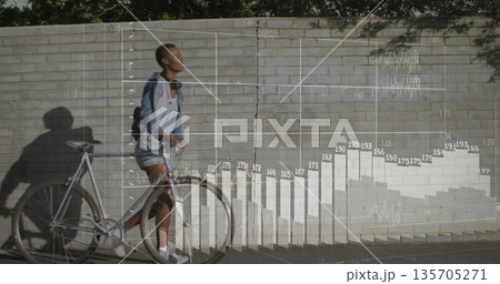 Walking casual woman pushing bicycle by brick wall, overlaid bar chart and line graph, copy space Walking casual woman pushing bicycle by brick wall, overlaid bar chart and line graph, copy space 135705271