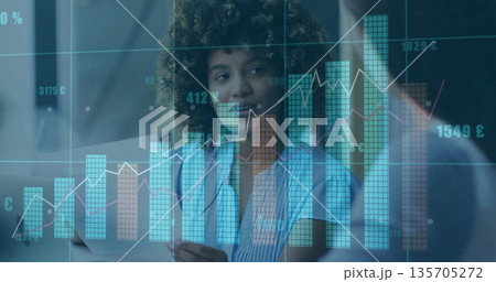 Curly-haired professional reviewing financial data overlays in modern office, with tablet Curly-haired professional reviewing financial data overlays in modern office, with tablet 135705272