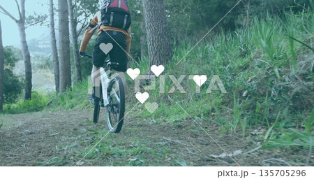 Riding male cyclist navigating pine-needle trail in forest, with mountain bike, helmet and backpack 135705296