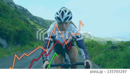 Riding female cyclist climbing mountain road, with road bicycle, helmet and data overlay 135705297