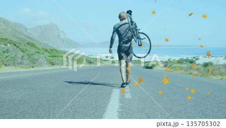 Walking male cyclist carrying bicycle over shoulder along coastal highway, wearing cycling outfit Walking male cyclist carrying bicycle over shoulder along coastal highway, wearing cycling outfit 135705302