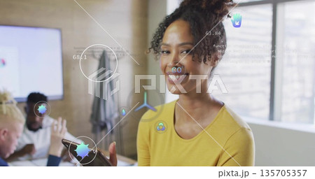 Presenting Hispanic mid adult woman holding tablet in office conference room, with digital overlays 135705357