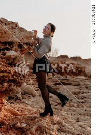 Woman Rock Climbing Outdoors: Sunset photoshoot showcasing adventurous spirit. Woman Rock Climbing Outdoors: Sunset photoshoot showcasing adventurous spirit. 135705621