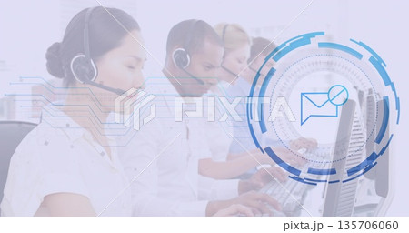 Typing at computer keyboards call center agents in office, with headsets and digital envelope icon Typing at computer keyboards call center agents in office, with headsets and digital envelope icon 135706060