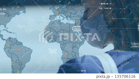 Analyst wearing face mask standing in control room, with world map and hex grid, copy space 135706116