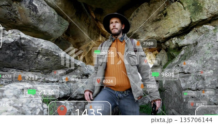 Exploring adult hiker wearing sunhat holding camera at rocky cave mouth, with data overlays Exploring adult hiker wearing sunhat holding camera at rocky cave mouth, with data overlays 135706144