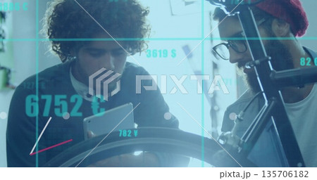 Examining two engineers reviewing tablet and bike wheel in workshop, with currency grid overlay Examining two engineers reviewing tablet and bike wheel in workshop, with currency grid overlay 135706182