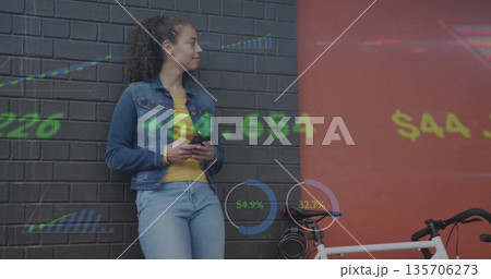 Woman denim-clad using smartphone leaning by white bike at urban corner, data overlay, copy space 135706273