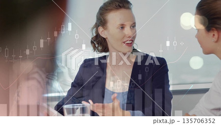 Female in navy blazer speaking and gesturing in conference room, with financial chart overlays Female in navy blazer speaking and gesturing in conference room, with financial chart overlays 135706352