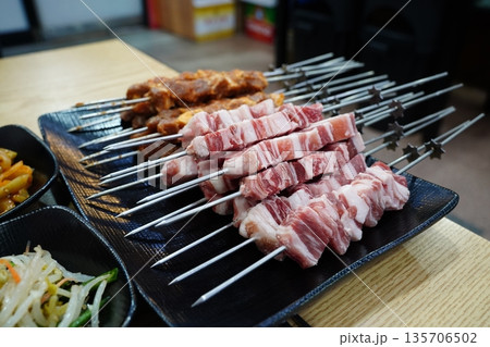 Raw and Marinated Lamb Skewers Prepared on a Black Plate Raw and Marinated Lamb Skewers Prepared on a Black Plate 135706502