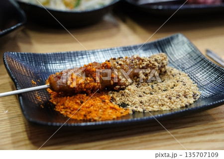 Grilled Lamb Skewer with Cumin, Chili, and Sesame Spices on a Black Plate 135707109