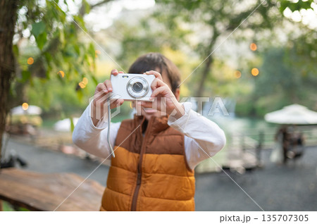 Young Boy Joyfully Capturing The Moment With A Small Camera 135707305