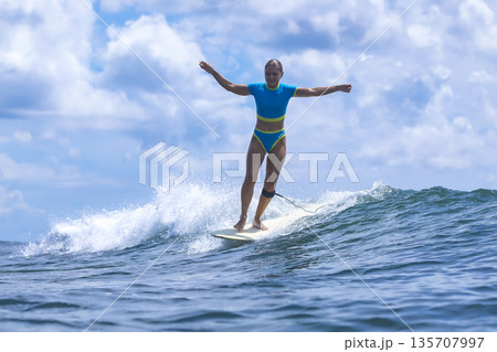 Energetic Female Surfer Demonstrates Control In Dynamic Summer Training Session Energetic Female Surfer Demonstrates Control In Dynamic Summer Training Session 135707997