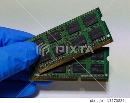 ノートパソコン（PC）のメインメモリ（RAM）2枚を手に持つ 135708254
