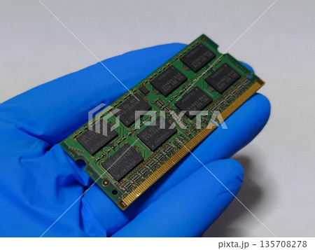 ノートパソコン(PC)のメインメモリ(RAM)1枚を手に持つ ノートパソコン(PC)のメインメモリ(RAM)1枚を手に持つ 135708278