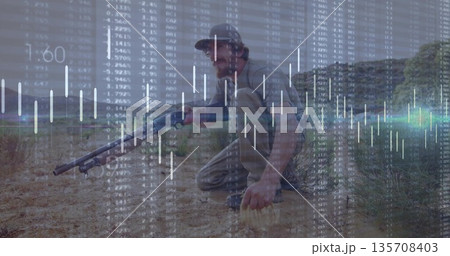 Kneeling tactical man holding rifle with headset in dry scrubland, with financial chart overlay 135708403
