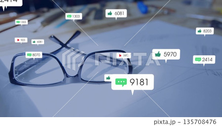 Resting black eyeglasses on paper with sketches at studio desk with art supplies, engagement icons 135708476