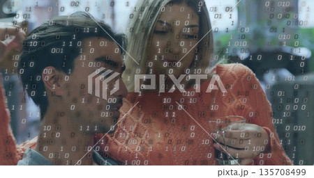 Sitting Asian man and White woman in cafe lounge, with clear glass and binary code overlay 135708499