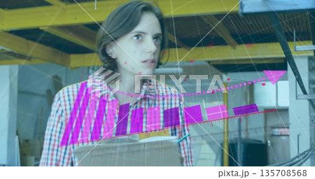 Holding woman in checkered shirt manipulating cardboard box in warehouse, with AR charts and graphs 135708568