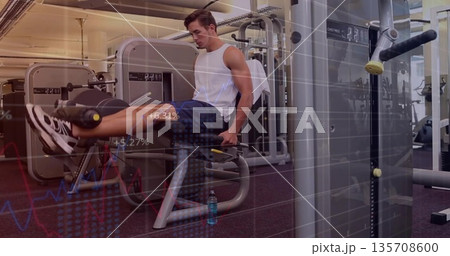 Using leg extension machine, man training quads near weight machines in gym with water bottle Using leg extension machine, man training quads near weight machines in gym with water bottle 135708600