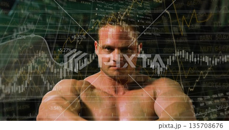 Showing shirtless athlete flexing muscles in studio, with stock market graphs and tickers Showing shirtless athlete flexing muscles in studio, with stock market graphs and tickers 135708676