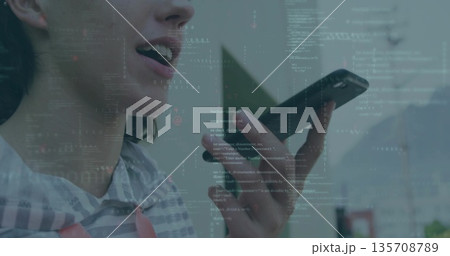 Speaking coder in striped sweatshirt holding phone at mouth in room, with code overlay, copy space 135708789