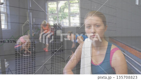 Holding white towel, woman wearing blue-pink tank top in studio with chart overlay, copy space 135708823