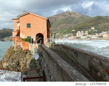 Traditional Ligurian building on island in sea. Landscape on cloudy sunny day. Nature in Italy. Traditional Ligurian building on island in sea. Landscape on cloudy sunny day. Nature in Italy. 135709076