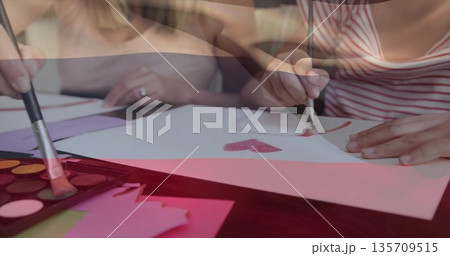 Painting girl in red tank top painting heart at craft area, with watercolor palette, copy space 135709515