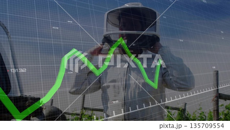 Adjusting VR headset, man in protective coat viewing green line chart overlay over vineyard rows Adjusting VR headset, man in protective coat viewing green line chart overlay over vineyard rows 135709554