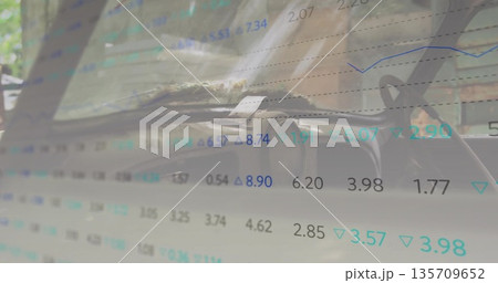 Showing car dashboard and steering wheel inside parked vehicle, with financial data overlay 135709652