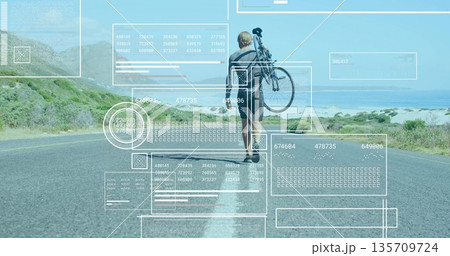 Walking mid-adult man carrying bicycle over shoulder on coastal highway road, with data overlays Walking mid-adult man carrying bicycle over shoulder on coastal highway road, with data overlays 135709724