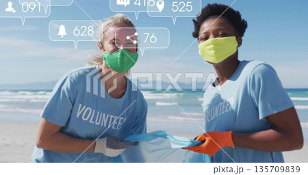 Volunteer women collecting litter in blue bag on beach, with masks, gloves and notification icons Volunteer women collecting litter in blue bag on beach, with masks, gloves and notification icons 135709839