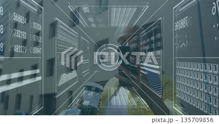 Examining tech analyst studying holographic data panels in office, holding smartphone and booklet 135709856