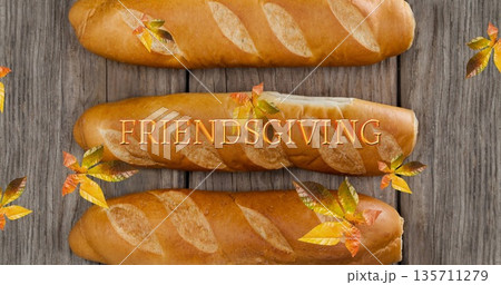 Image of friendsgiving text over fall leaves and bread 135711279