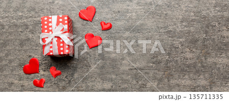 Valentine day composition: red gift box with bow and heart. Christmas present. View from above. Space for text. Holday greeting card 135711335