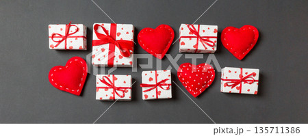 Top view colorful valentine background made of gift boxes and red textile hearts. Valentine's Day concept with copy space Top view colorful valentine background made of gift boxes and red textile hearts. Valentine's Day concept with copy space 135711386