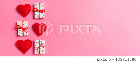 Holiday composition of gift boxes and red textile hearts on colorful background with empty space for your design. Top view of Valentine's Day concept Holiday composition of gift boxes and red textile hearts on colorful background with empty space for your design. Top view of Valentine's Day concept 135711390